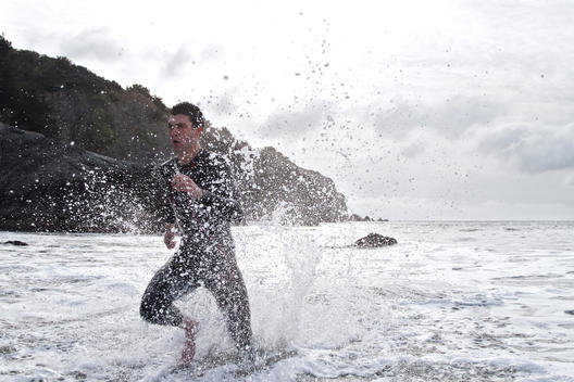 A Triathlete exits the ocean during a training workout