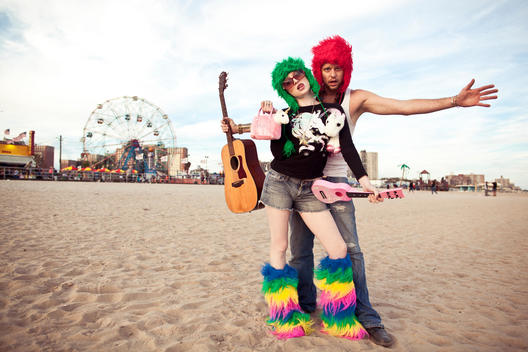 guy and girl with crazy colorful clothes standing on the beach