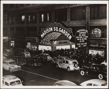 View Outside Madison Square Garden. Taxicabs, Other Automobiles, And A Queue Of People Are Visible In Front. The Marquee Advertises Sonja Henie And Her Ice Review And A Boxing Match: Jack Vs. Angott.