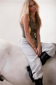 Young Woman Sitting On White Horse