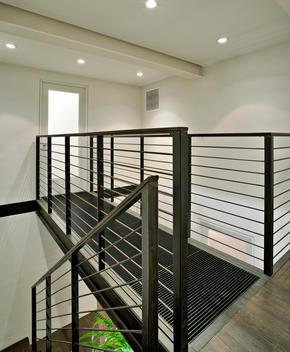 Iron Catwalk Leading To Closed Frosted Glass Door And Descending Staircase