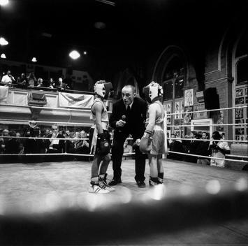 The Referee Stoops Down To Explain The Rules To Two Amateur Boxers Before The Opening Round Of Their Bout In The All-Stars Boxing Club