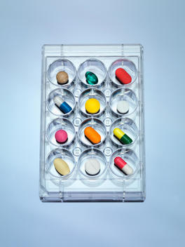 A variety of drugs sitting in a multi well sample tray Illustrating drug clinical trial