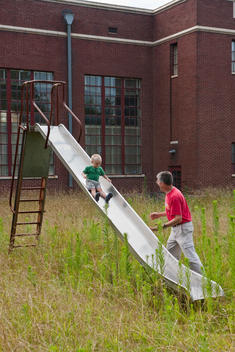Boy And Grandfather Play On A Old Slide