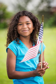 Mixed race girl waving American flag