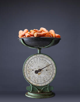 Fresh carrots on top of vintage kitchen scales