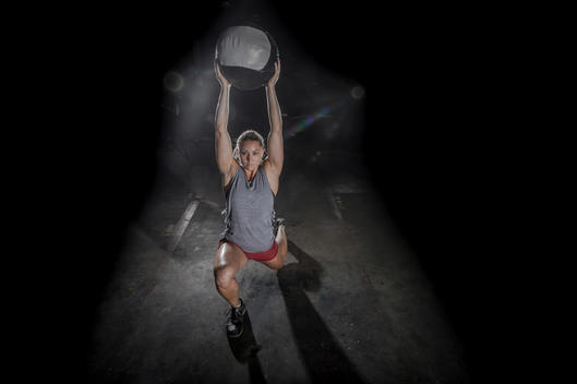 Girl lifting a ball at a crossfit gym