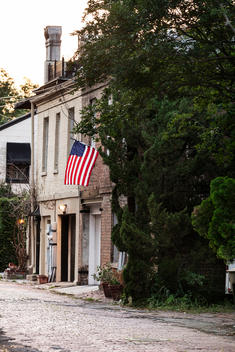 Exterior of old colonial brick house with American flag