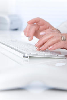 Woman\'s hand typing on a keyboard