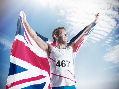 Track and field athlete holding British flag and celebrating