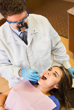 Dentist examining patient\'s teeth in office