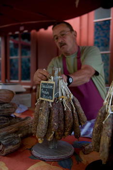 A local man sells dried cured meats on his market stall in the town of Laruns during their cheese festival