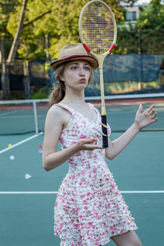 girl balancing a badminton racquet on finger