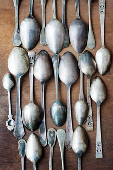 Still life with rows of vintage spoons on table