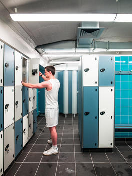 Man in gym changing room, Golden Lane Leisure Centre design renovation by Cartwright Pickard Architects, original design by Chamberlin Powell and Bon in 1952, Barbican, London, UK.