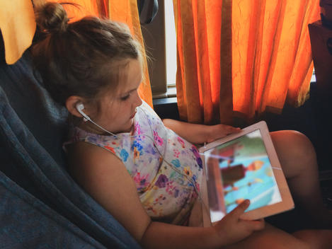Girl watching movie on tablet computer in the long distance bus
