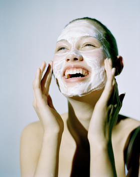 Beauty Model Applying Cream Mask To Face