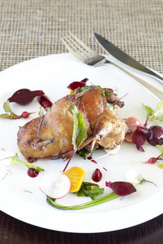Roasted Chicken With Beets And Radishes On White Plate With Utensils.