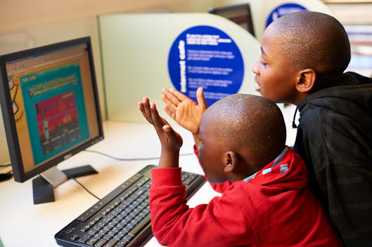 two boys playing computer game at a internet cafe