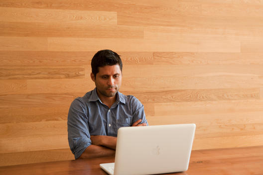 man contemplating behind laptop
