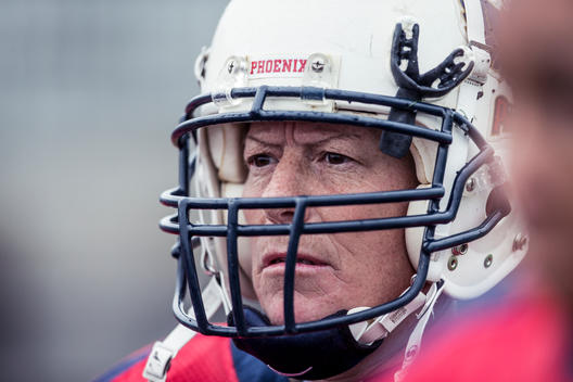 A close up portrait of a women\'s football player wearing her helmet prior to the start of a game.