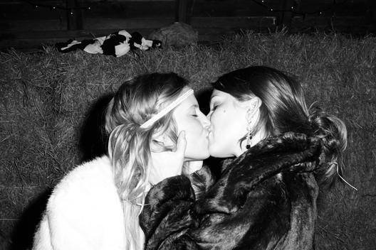 Two women kissing in barn