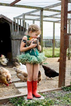 Young girl in tutu holding chicken