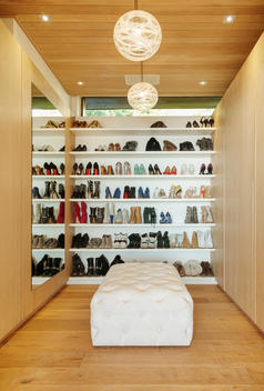 Modern walk-in closet with shoes on shelves