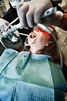 A Girl At An Orthodontist\'S Office With Tools And Hoses.