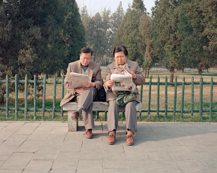 Older couple reading newspapers in Ditan park, Beijing, China, 2001