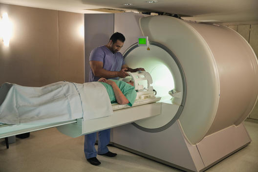 Male radiologist doing CT-Scan on female patient in hospital