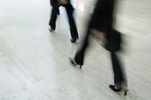 Business people walking, low section, blurred motion