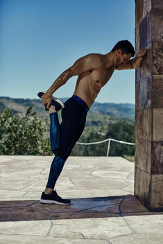 Shirtless fit male stretching after workout.