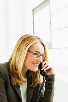 Germany, Businesswoman talking on telephone, smiling