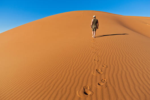 Africa, Namibia, Namib Naukluft National Park, Man walking on sand in the namib desert