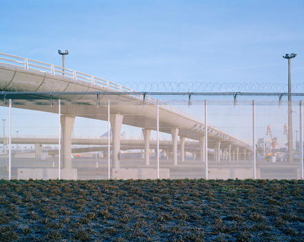 Calais flyover behind fencing and newly lain plants