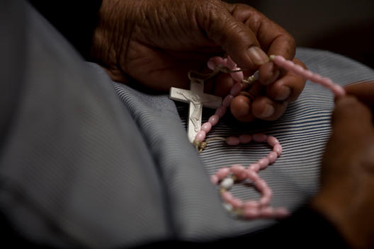 A woman prays the rosary in Our Lady of Guadalupe Home for the Elderly, Mexico City