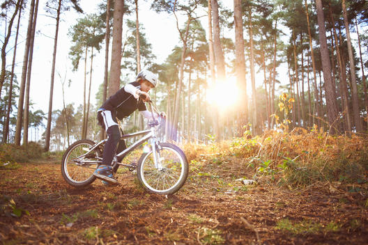 Boy riding his BMX through forest