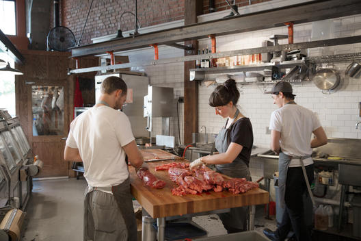Butchers prepare different cuts of meat at a butcher shop