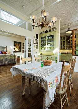 Country Kitchen With Crocheted Table Covering, Brass Light Fixture, Skylights And View Into Bedroom