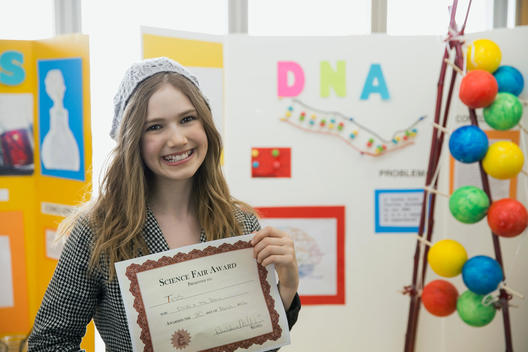 Portrait of school girl with award at science fair