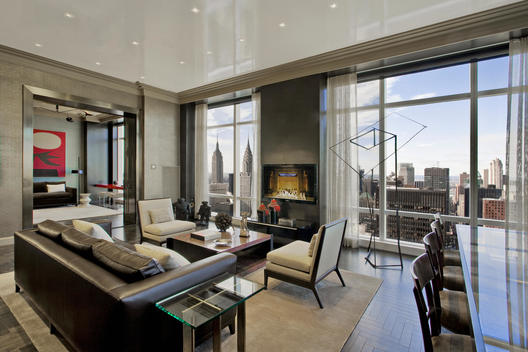 Penthouse Living Room With Leather Couch, Crown Molding, Dining Table And Sculptures