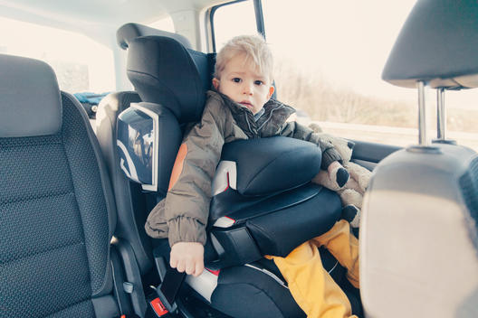Germany, Little boy sitting in back-seat car seat