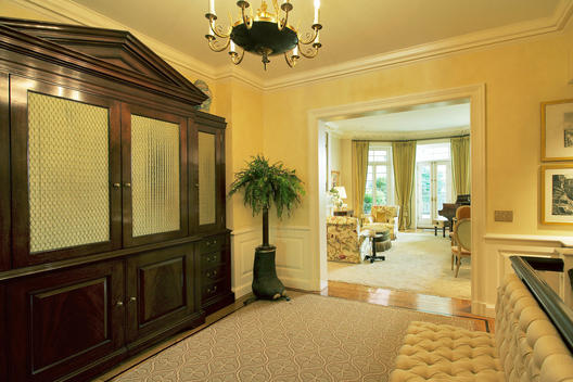 Second Floor Foyer With Large Antique Glass Case, Elephant Foot Planter And Living Room In Background
