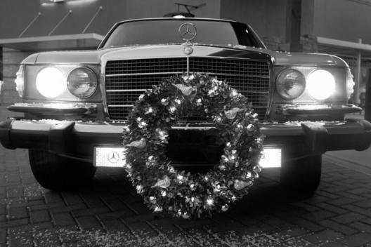 Vintage Mercedes Benz With Wreath And Headlights On At Night At Christmas Time