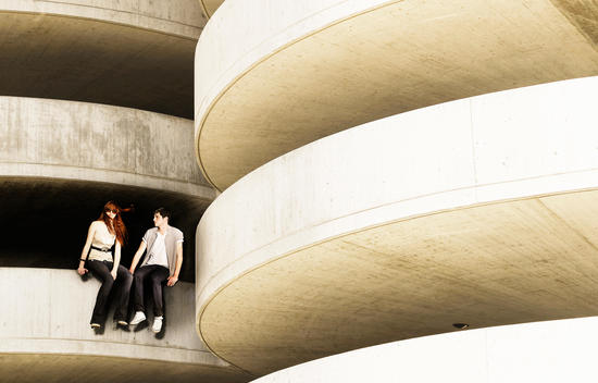 Male And Female Model Perched Among A Concrete Spiral
