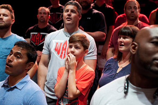 A boy in the audience at the arm wrestling competition in Las Vegas covers his mouth with his hands