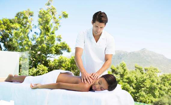 Woman receiving massage on patio at spa