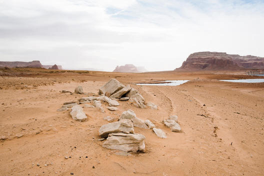 arid, moon-like landscape with white rocks in foreground by lake Powell in Arizona.