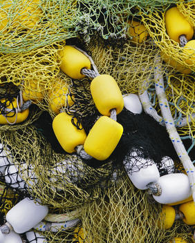 Pile of commercial fishing nets, with yellow and white floats, on the quayside at Fisherman\'s Terminal, Seattle.